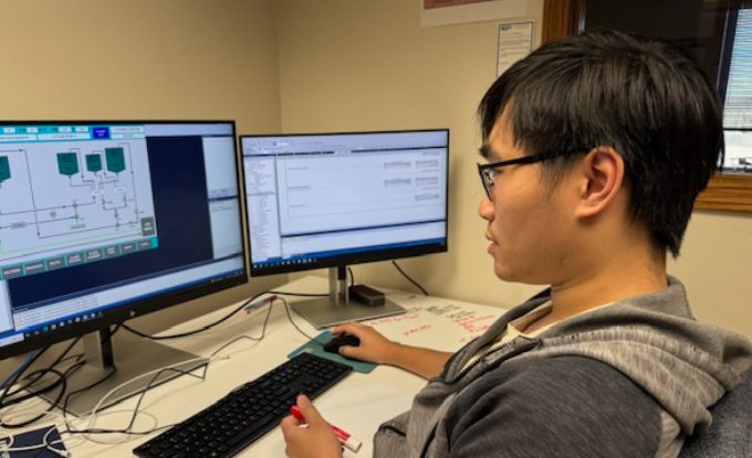 Engineer reviewing SCADA control-system screens at Huffman Engineering